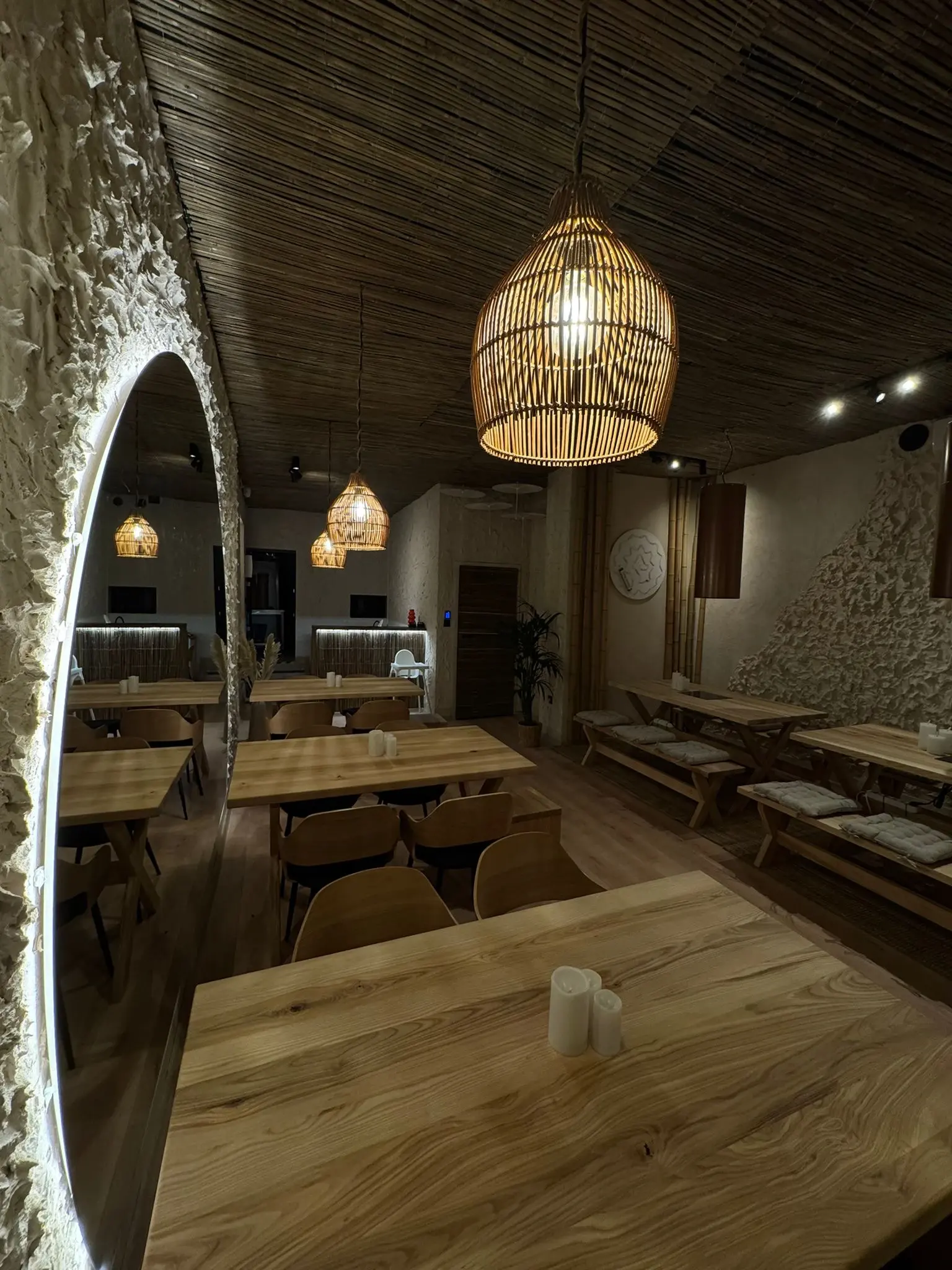 Wnętrze restauracji Dim Sum – drewniane stoły, rattanowe lampy i przytulna atmosfera.